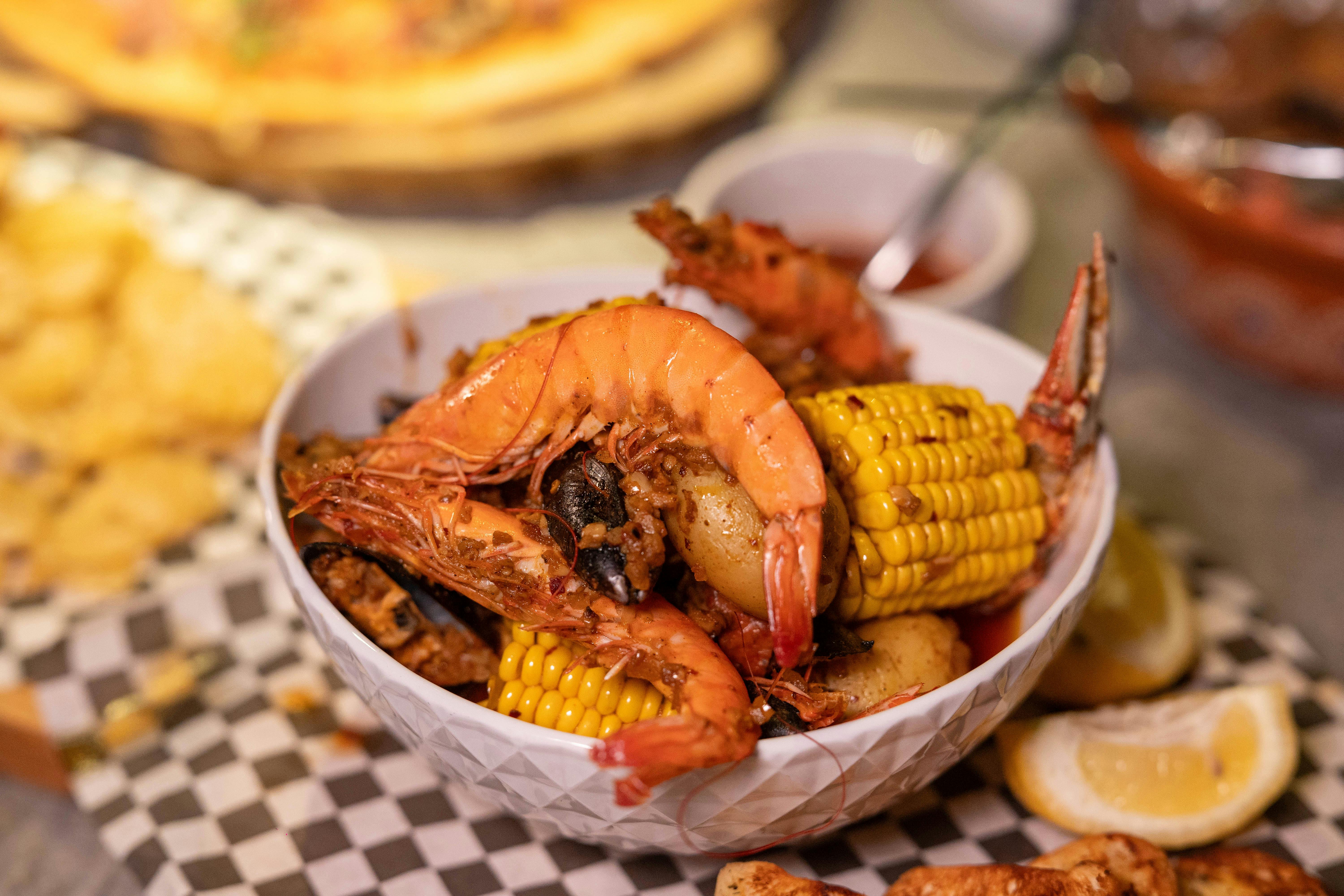 A vibrant seafood boil with shrimp, corn, and potatoes in a bowl, perfect for feast lovers.