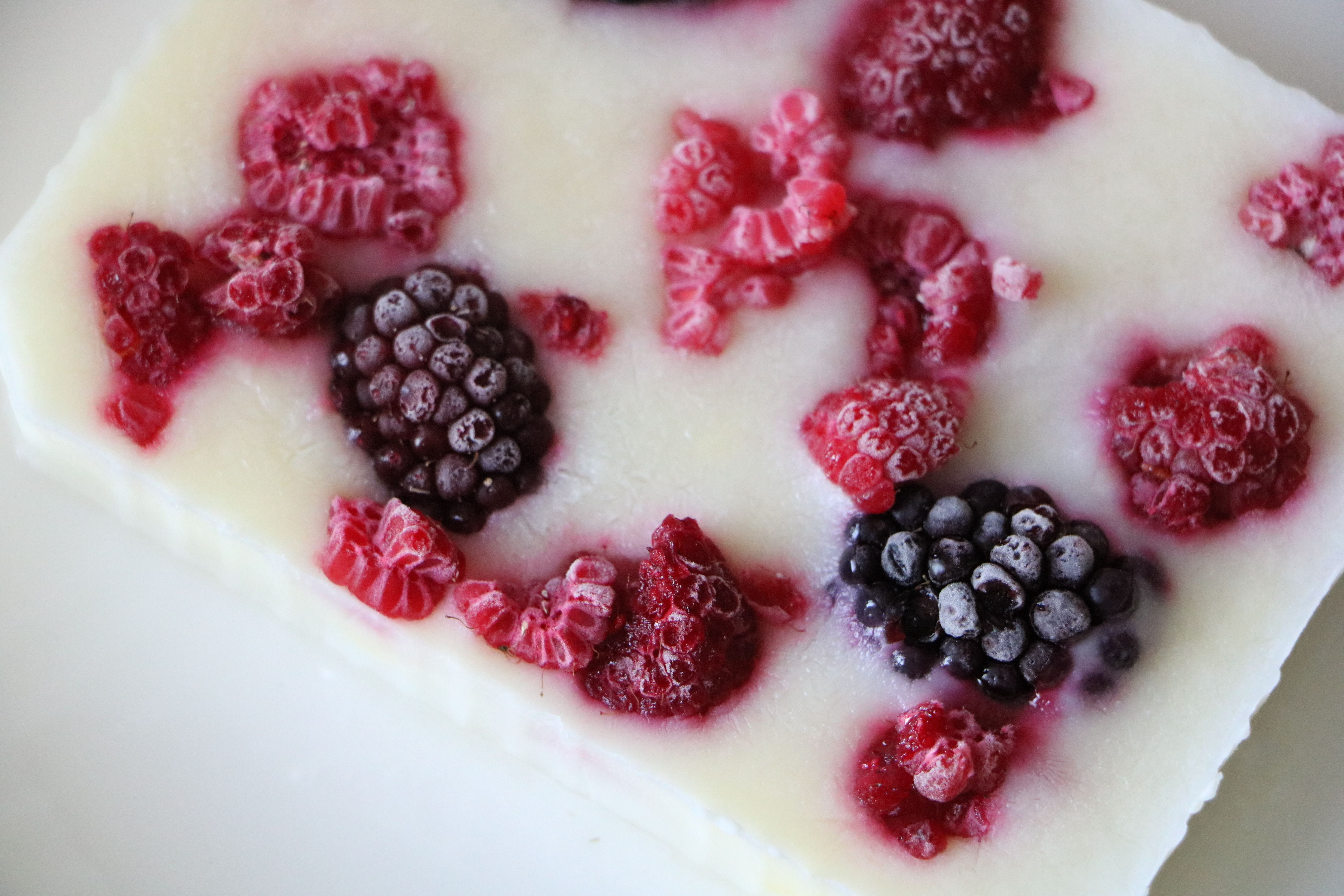 Close-up of frozen berries on a creamy yogurt bar, showcasing vibrant colors.