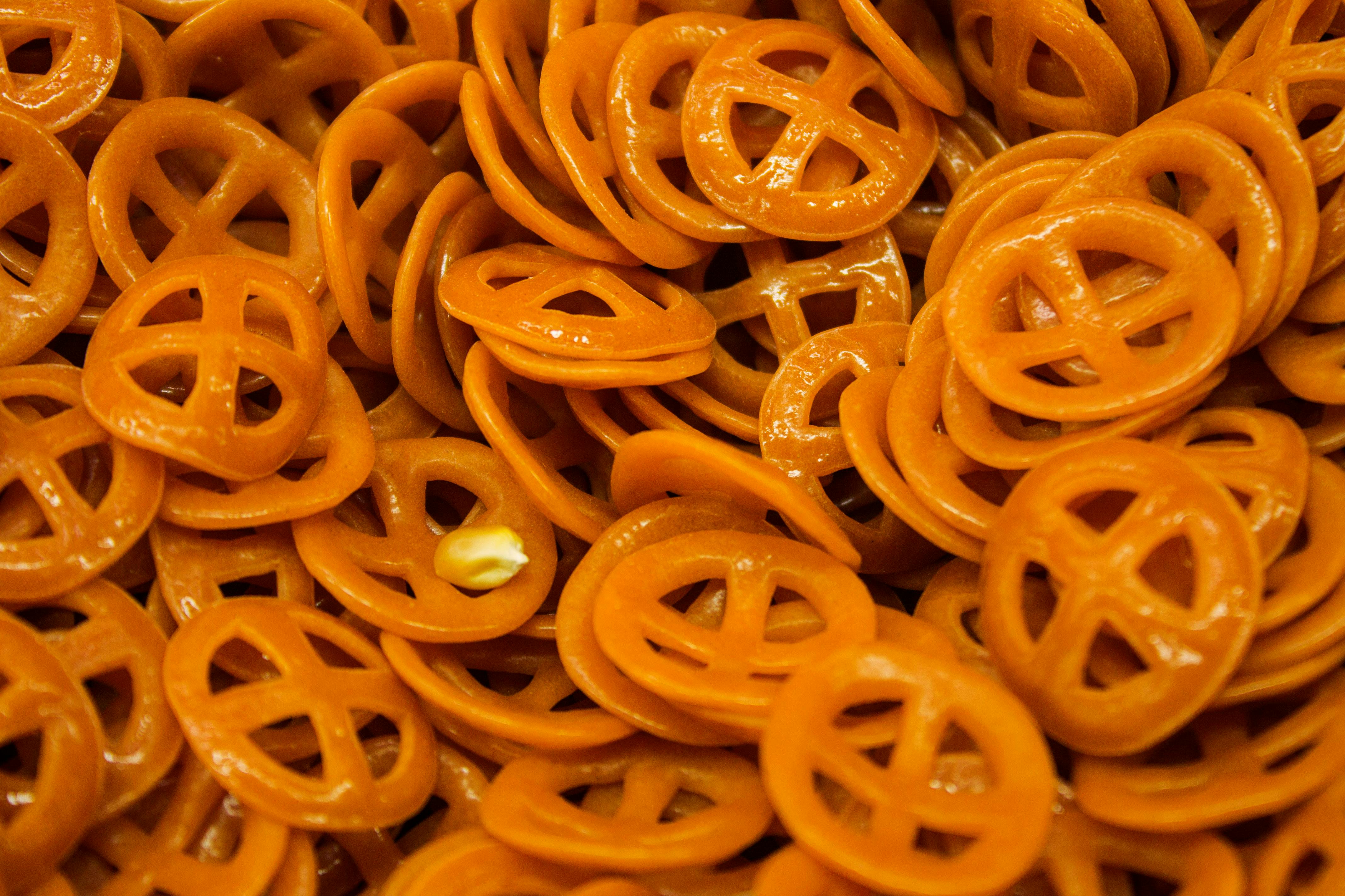 Vibrant close-up of crunchy, orange-colored pretzel snacks. Perfect for snack advertising.