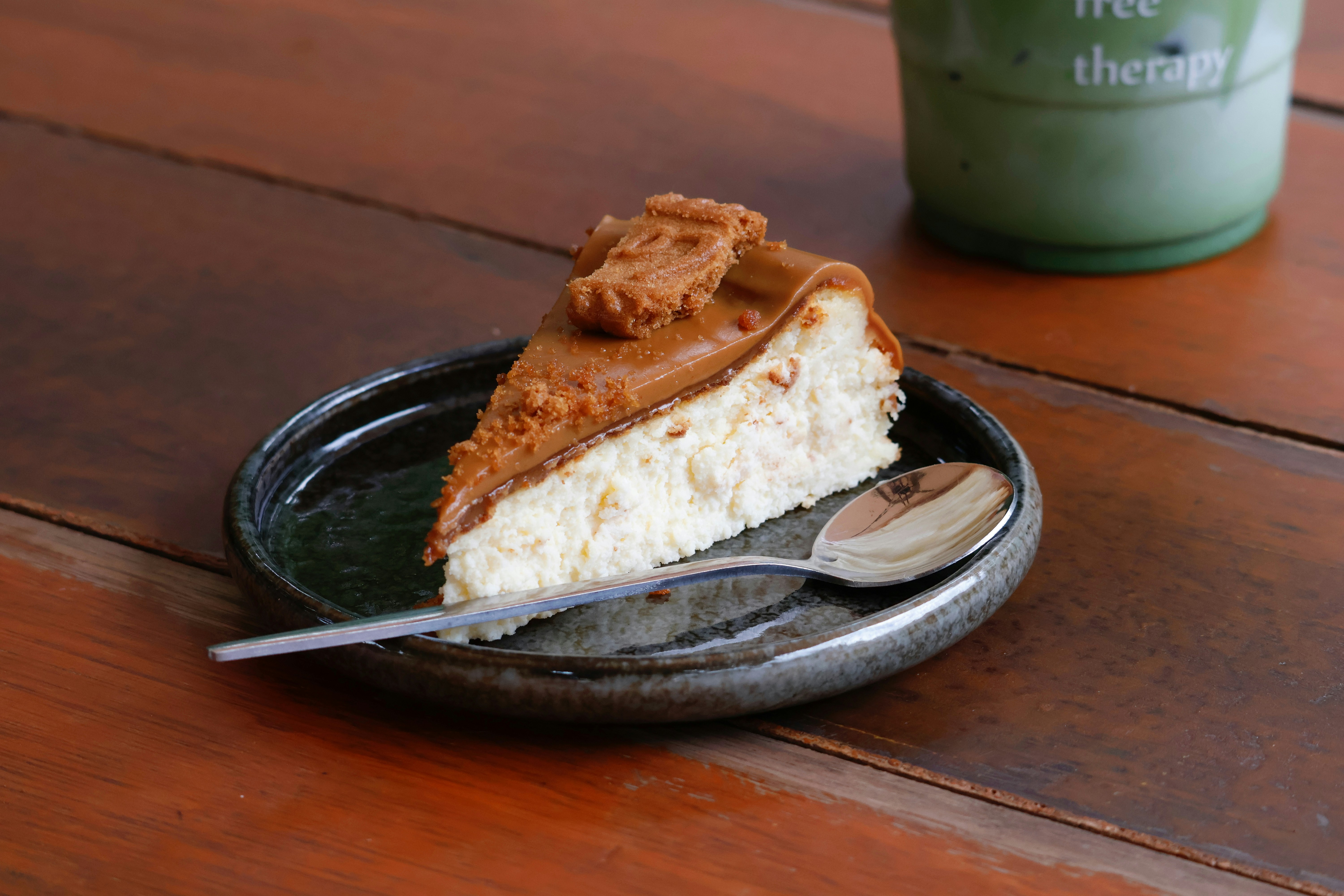 A slice of cheesecake with cookies on a plate.